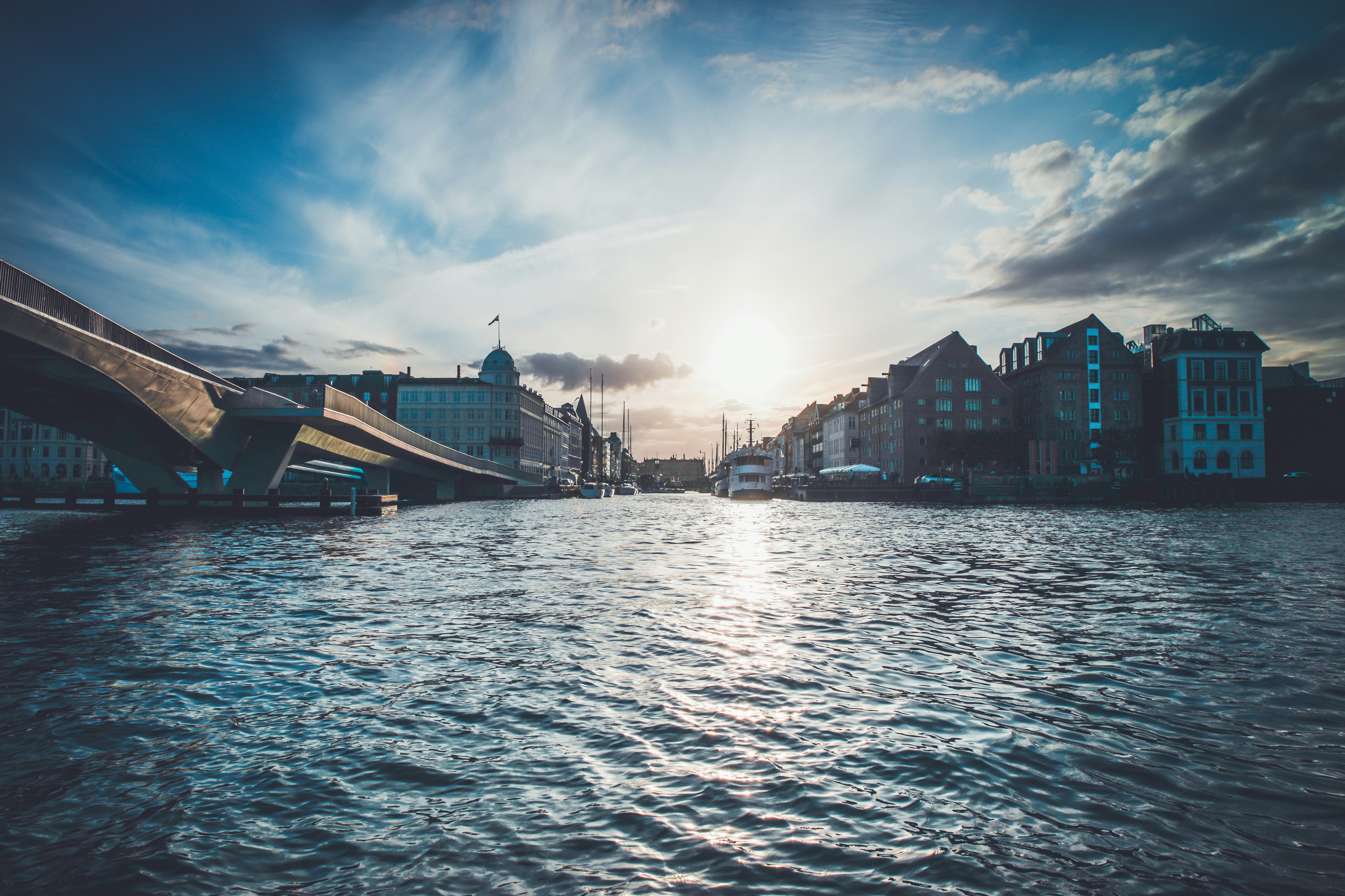 concrete bridge leading to city surrounded by water